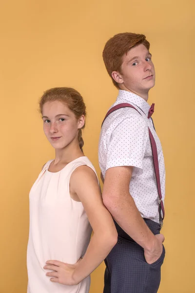Portrait of young  male and female teenagers standing back to ba