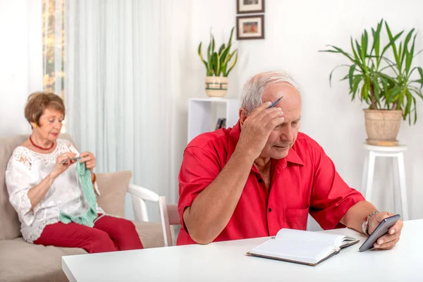 Aufnahme eines älteren Mannes mit einem Mobiltelefon bei der Planung seiner Tat — Stockfoto