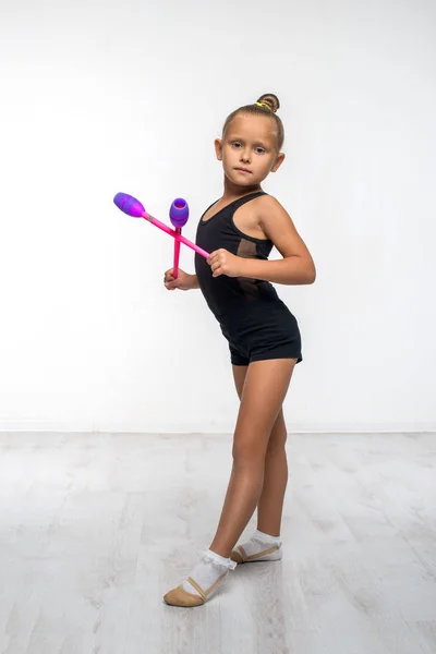 Menina ginasta atraente com um clube de ginástica rosa — Fotografia de Stock