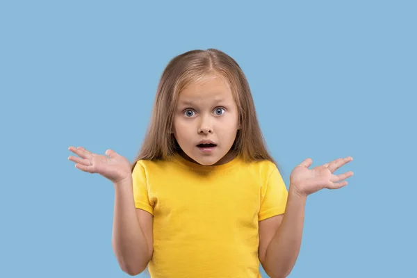 Een klein meisje die zijn armen naar de zijkant spreidt en spijt heeft van iets. — Stockfoto