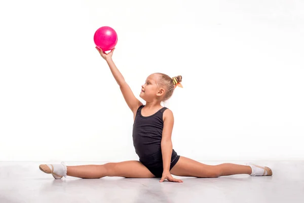 Estúdio tiro de atraente pequena menina ginasta com um ba rosa — Fotografia de Stock
