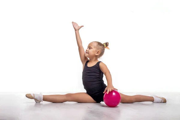 Studio shot de jolie petite fille gymnaste avec une ba rose — Photo