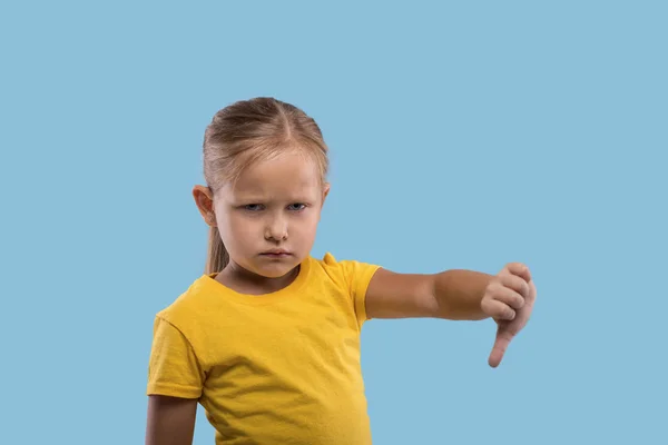 Una pequeña chica seria mostrando un gesto todo es malo agai —  Fotos de Stock