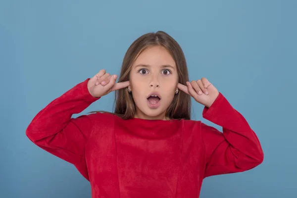 A young girl girl plugged her ears and screams, showing that she — Stock Photo, Image