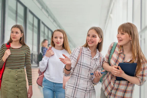 廊下に沿って学校や大学に行くリュックを持つ陽気な学生のグループ — ストック写真