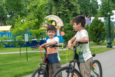 Dışarıda bisiklete binen iki küçük kardeşin portresi.