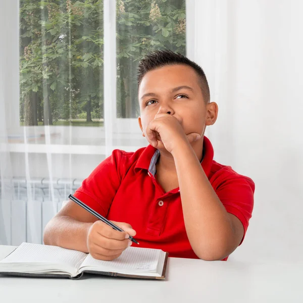 Skolpojken Sitter Vid Bordet Inomhus Och Tänker Ett Problem — Stockfoto