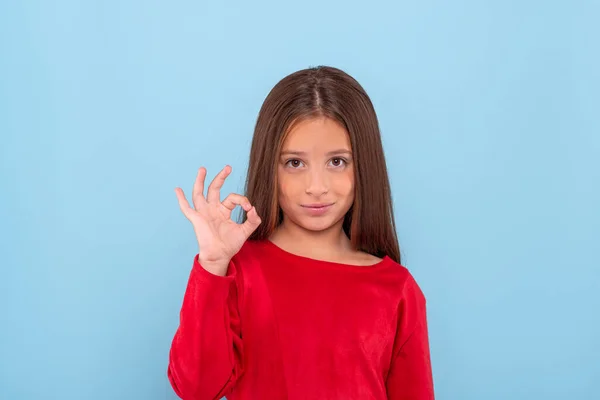 升起一个穿着红衫的男孩的情感画像 给你一个认可的手势 在蓝色背景下与复制空间隔离 — 图库照片