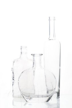 boş alkollü şişelerden cam yoluyla beyaz arka planda su damlaları ile bileşim