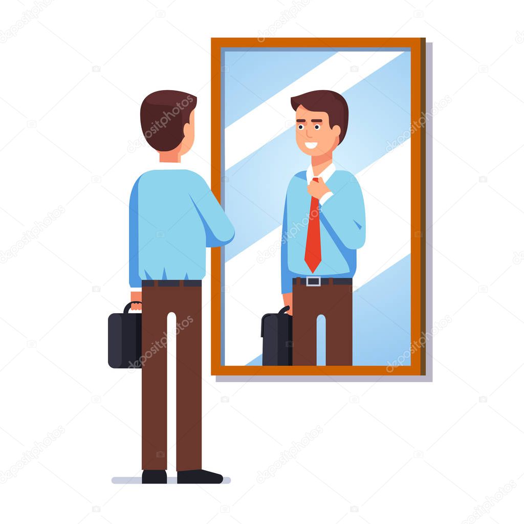 Bbusiness man looking at reflection in wall mirror