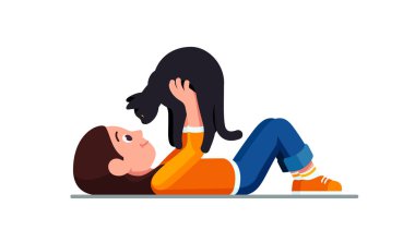 Happy girl lying and holding cat above herself clipart