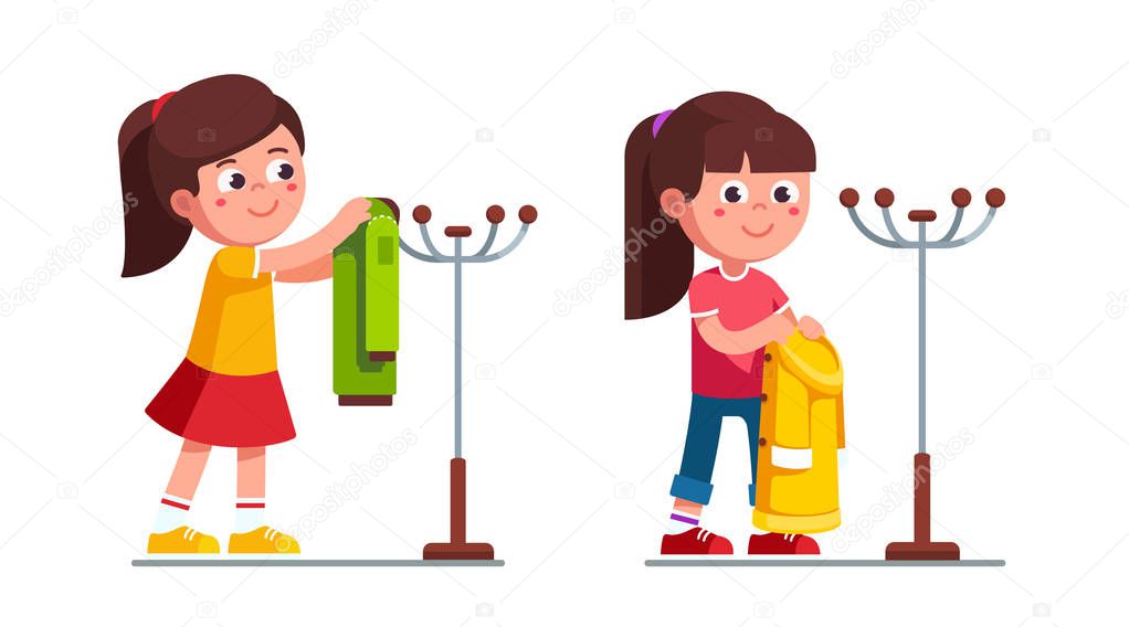 Little girls holding, hanging coat on hanger stand