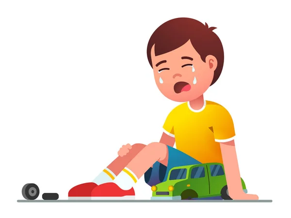 Sorglig pojke unge sitter och gråter över trasiga leksaksbil — Stock vektor