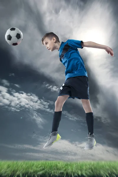 football player hitting the ball with head on a soccer stadium