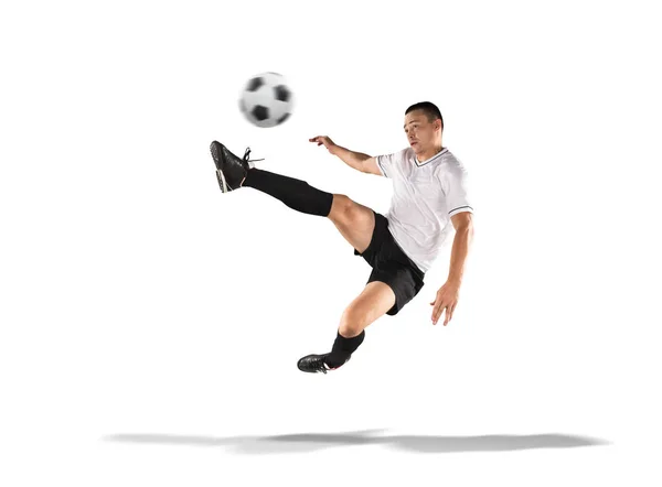 Футболист пинает мяч в воздух изолированный на белом — стоковое фото
