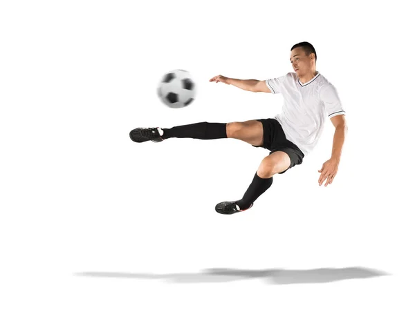 Voetballer schoppen de bal in de lucht geïsoleerd op wit — Stockfoto