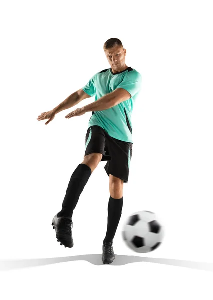 Футболист пинает мяч в изолированном на белом — стоковое фото
