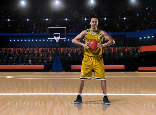 Jugador de baloncesto en uniforme amarillo de pie en la cancha de baloncesto — Foto de Stock