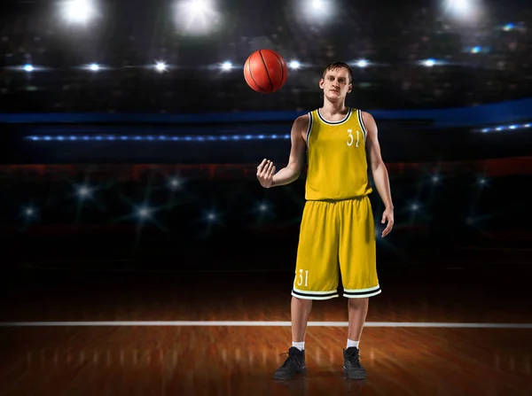 Баскетболист в желтой форме, стоящий на баскетбольной площадке — стоковое фото
