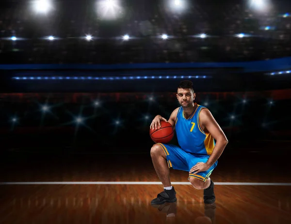 Баскетболист в синей форме сидит на баскетбольной площадке — стоковое фото