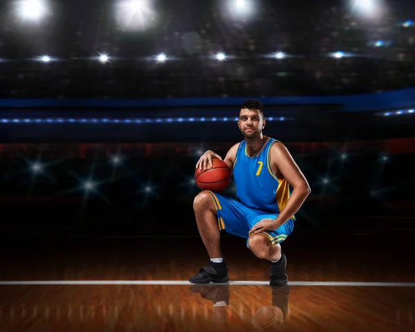 Basketballspieler in blauer Uniform sitzt auf Basketballfeld — Stockfoto