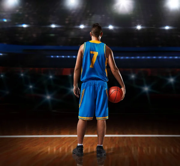 Μπασκετμπολίστας σε μπλε στολή στέκεται στο γήπεδο μπάσκετ — Φωτογραφία Αρχείου
