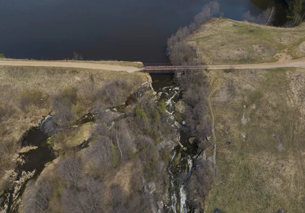 Un estanque en el pueblo de Gileva, una presa, un puente de carretera y una pequeña cascada. Soleado, primavera, aéreo . — Foto de Stock