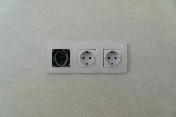 Dos tomas de corriente y libres con marco en la pared blanca como fondo — Foto de Stock