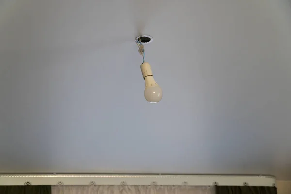 Диодная лампочка, свисающая с потолка проволоки. Одинокий бу — стоковое фото