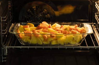 dilimlenmiş patates ve havuç fırında bir cam plaka, yan fotoğraf