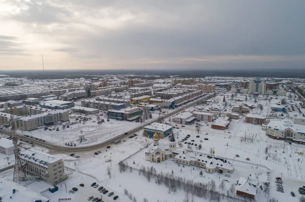 Chiesa e città edificio amministrativo nella città di Yugorsk. Aereo. Inverno, neve, nuvoloso. Khanty Mansiysk Autonomous Okrug (HMAO), Russia . — Foto Stock