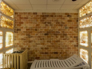 Spa merkezindeki tuz odası, ahşap banklar ve plastik güneş pansiyonları.