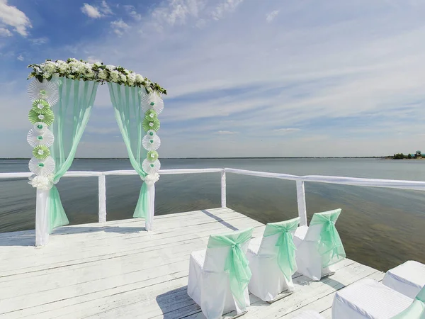 Place for wedding ceremony. Pier on bank of lake, Wedding arch