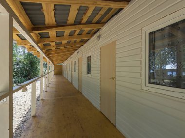 Oda, konuk evi önünde teras koridorunun girişine girin, uzun ve dar bir geçit sonu. Ahşap zeminler, ağaçlar, korkuluklar ve avludaki ağaçların yemyeşil yeşillikleri
