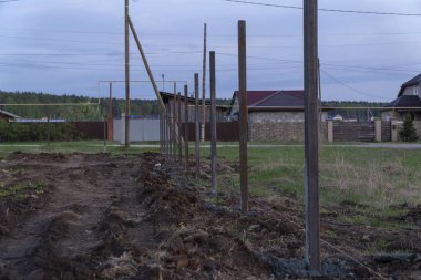 çit inşaat, betonarme metall sütun. Akşam, gün batımı