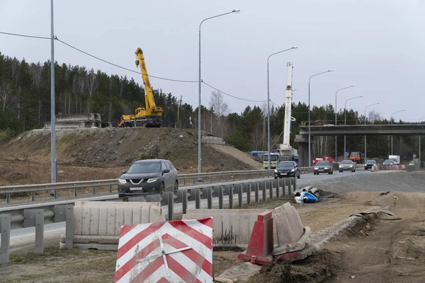 Nova ponte rodoviária em construção sobre a rodovia. Guindastes de caminhão fazendo trabalho — Fotografia de Stock