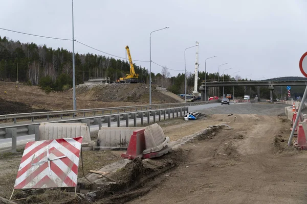 Nova ponte rodoviária em construção sobre a rodovia. Guindastes de caminhão fazendo trabalho — Fotografia de Stock