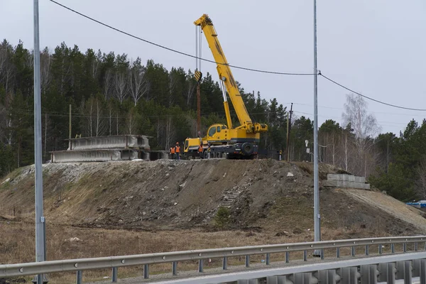 Nova ponte rodoviária em construção sobre a rodovia. Guindaste caminhão fazendo trabalho — Fotografia de Stock