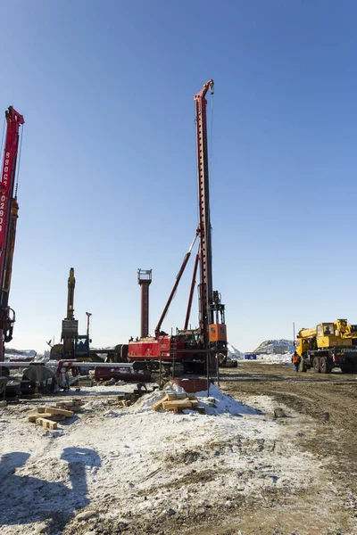 Sprzęt wiertniczy, koparki, ciężarówki budować port morski Sabetta. Yamal, Rosja. Zima, słonecznie — Zdjęcie stockowe