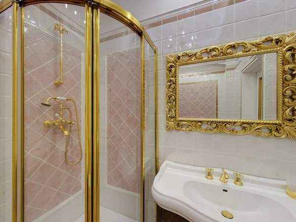 Ekaterinburg, Rusia. Octubre 01, 2014. Aseo de lujo interior y baño con luz cálida. Cuarto de baño cabina de ducha, lavabo, grifo, espejo. Decoración dorada — Foto de Stock