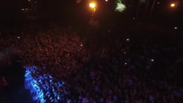 祭りの観客の空中ビュー彼らの手を上げている 森の中で夜の野外コンサート 祭りの群衆が手を上げて — ストック動画