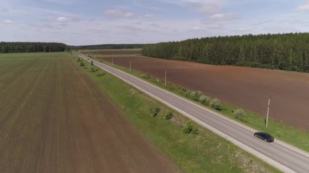Düz Bir Asfalt Yolda Giden Siyah Yolcu Aracının Hava Görüntüsü — Stok video