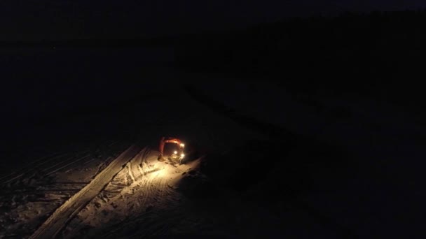 掘削機の空中ビューは フィールド内の夜にライトで動作します — ストック動画