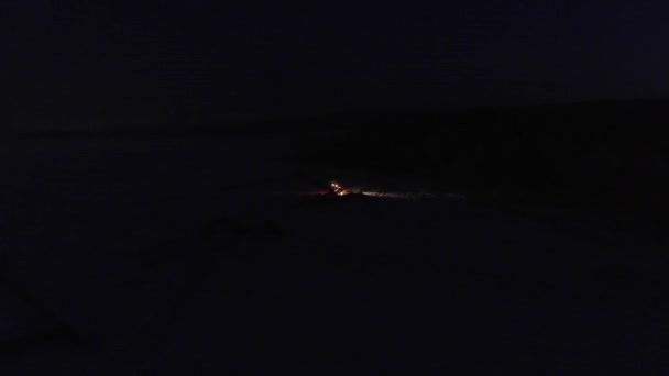 フィールド内の夜間桁パイプライントレンチ上の照明付き掘削機の空中ビュー — ストック動画