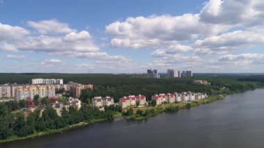 Şehirdeki nehir kıyısındaki modern çok katlı evlerin havadan görünüşü. Ormanın etrafında. Güneşli bir yaz günü. Rusya, Ekaterinburg