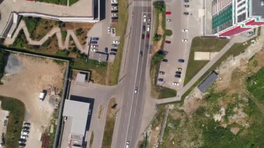 Havadan bakıldığında şehrin modern yerleşim birimleri. Yakınlarda bir inşaat alanında. Arabalar cadde boyunca sürer. Yaz güneşli bir gün
