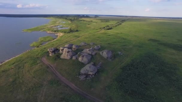 Widok Lotu Ptaka Ogromne Kamienie Skały Rozległym Polu Nad Jeziorem — Wideo stockowe