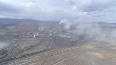 Karabaş şehrindeki bakır fabrikasının havadan görüntüsü. Kirlenmiş bölgenin etrafında. Duman bacadan çıkar ve kameraya doğru uçar. Arabalar yolda gidiyor. Rusya, Chelyabinsk bölgesi
