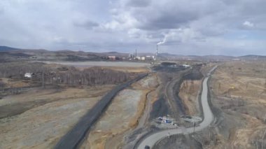 Karabaş şehrindeki bakır fabrikasının havadan görüntüsü. Duman bacadan çıkıyor. Kirlenmiş bölgenin etrafında. Arabalar yolda gidiyor. Rusya, Chelyabinsk bölgesi
