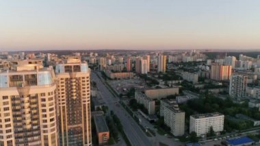 Akşam şehrindeki gökdelenlerin hava görüntülerine göre gün batımında önemli bir yerleşim bölgesinde. Arka planda modern şehir. Çatıdaki ve partideki insanlar